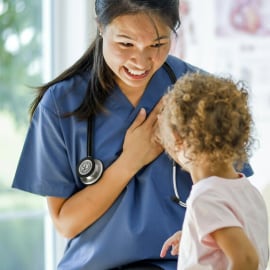 Una doctora sonriendo con un paciente infantil.