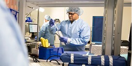 healthcare professional in protective clothing working in a lab facility setting
